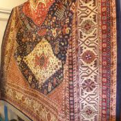 A Caucasian design carpet with three diamond lozenges on a midnight blue field surrounded by one