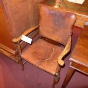 A C19th armchair upholstered in leather and raised on stretchered supports