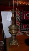 A pair of Continental brass table lamps of bulbous form with extensive decoration in relief on paw