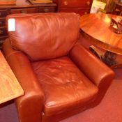 A contemporary armchair upholstered in brown leather