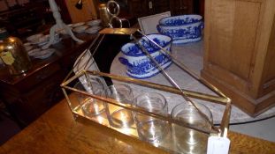 A gold coloured candle holder with four large glasses