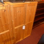 A contemporary pine side cabinet with pair of panel doors enclosing shelves