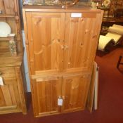 A pair of contemporary pine cabinets fitted pair of panel doors enclosing shelves