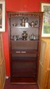 An open bookcase of narrow proportions with carved and pierced detail