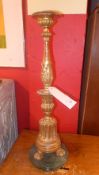 A C19th carved giltwood altar candlestick raised on a circular marble base
