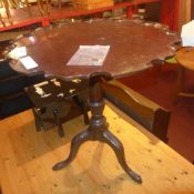 A Georgian mahogany pie crust occasional table raised on turned column and tri form supports (A/F)