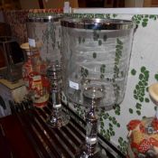 A pair of glass and silver plated table top storm lanterns of large size