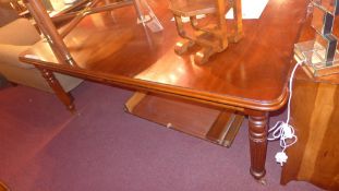 A Victorian style mahogany extending dining table with one extra leaf and raised on reeded
