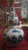 A Chinese double gourd shaped vase decorated with landscape reserves in blue and orange