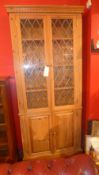 A pine side cabinet fitted pair of glazed panel doors above a further pair of cupboard doors