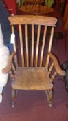 A C19th stick back rocking chair with solid seat raised on turned supports