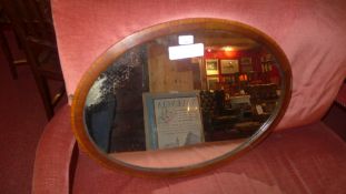 An Edwardian inlaid mahogany mirror with oval plate