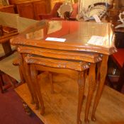 A nest of three low tables with tooled l