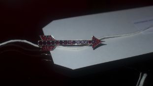 An arrow form white metal and garnet bro