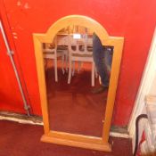 An oak wall mirror with arched plate