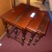 A nest of three oak low tables on stretc
