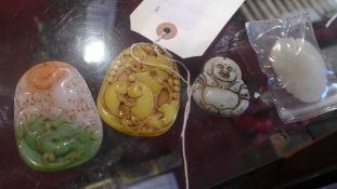 Four Chinese jade and similar carved pendants
