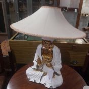 A 1950`s porcelain table lamp in the form of a meditating Buddha glazed in white and heightened in
