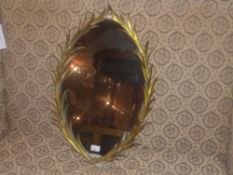 An oval shaped looking glass in leafy gi