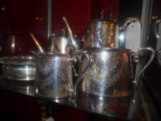 A silver plated four piece tea set with engraved detail and a silver plated coaster