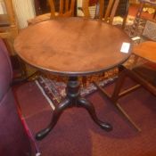 A Georgian mahogany occasional table the circular dish top raised on turned column and trform