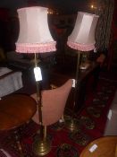 A pair of brass standard lamps with reed