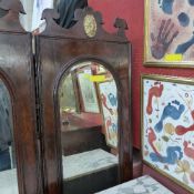 An antique walnut hall mirror the arched