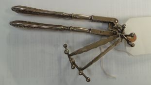 A pair of continental silver knife rests together with a French nut cracker