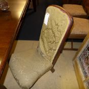 A Victorian rosewood nursing chair in floral detail on turned feet