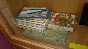 A quantity of photos, postcards and ciga