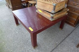 A C20th red lacquered square low table with brass feet