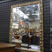 A silvered carved wall mirror with bevelled plate