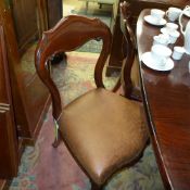 A set of four Victorian mahogany dining chairs with faux leather seats on reeded supports