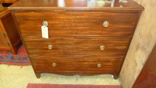 A Georgian mahogany chest of three graduated drawers raised on shaped bracket supports with brass