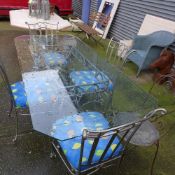 A wrought iron glass conservatory table with eight matching chairs