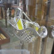 A silver plated wine bottle cradle