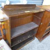 A walnut open bookcase on plinth base