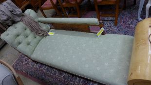 An Edwardian carved walnut chaise longue with scroll arm above stuff-over seat upholstered in a