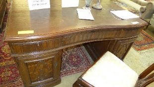 An early C20th oak pedestal desk the con