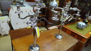 A pair of plated five light candelabra on round base