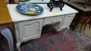A French white painted desk the rectangular top above drawer flanked by cupboards