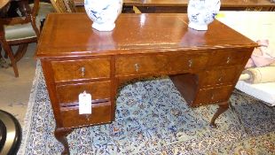 An early C20th walnut kneehole desk the tooled leather top above drawers on squat cabriole