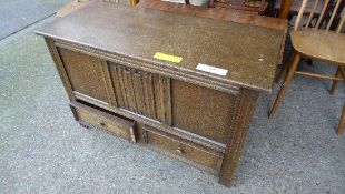 An oak linen fold panel coffer with base drawers
