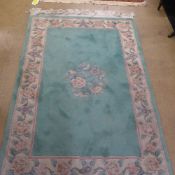 A hand knotted Chinese rug the green ground with floral border