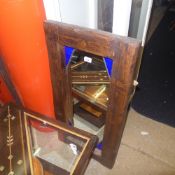 A hardwood wall mirror with coloured gla