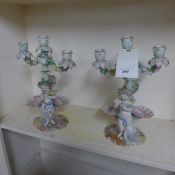A pair of Meissen style candlestick with cherub and maiden relief