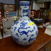 A pair of bulbous blue and white Chinese style vases with dragon relief