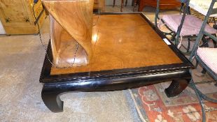 A black lacquered Chinese style low table with glass on the top