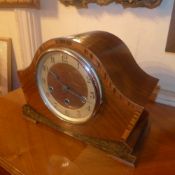 An Art Deco inlaid and crossbanded walnut mantel clock with circular steel dial and key