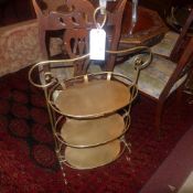A pair of gold painted oval form three tier etergeres